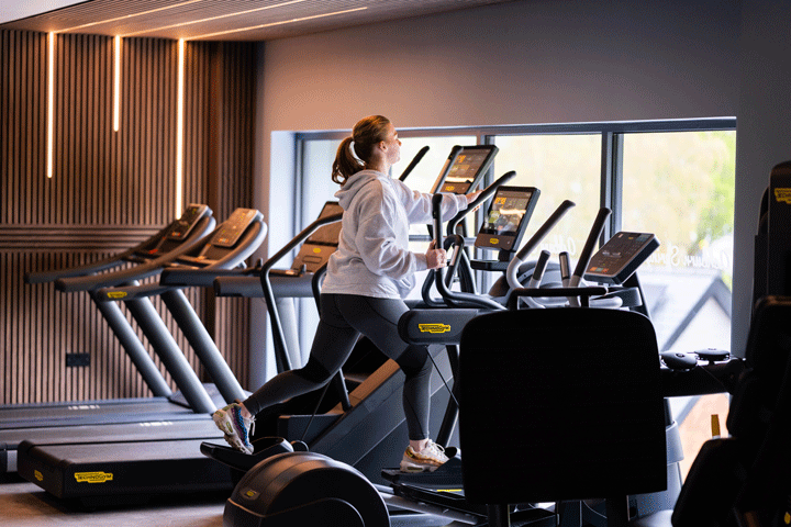A girl using a fitness machine in the gym at Cofton