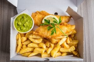 fish and chips with peas and slice of lemon and royalty free image 884635802 1548434060