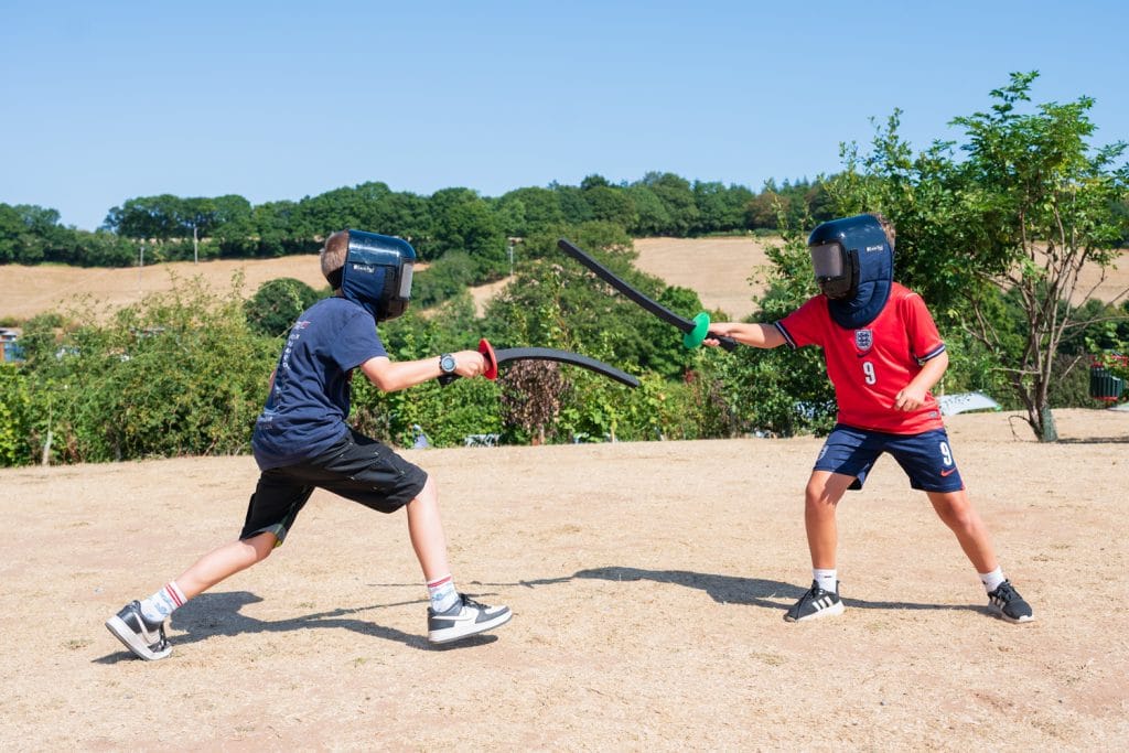 two children fencing with foam swords