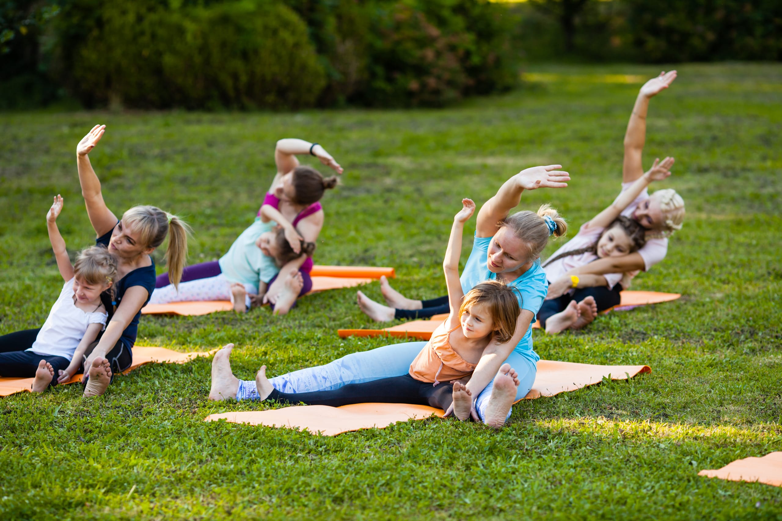 Yoga with children Children and their parents performing a stretch exercise as part of a classes